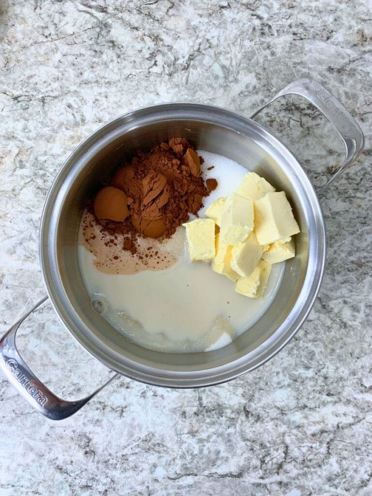 a saucepan containing cocoa powder, butter, sugar, and milk