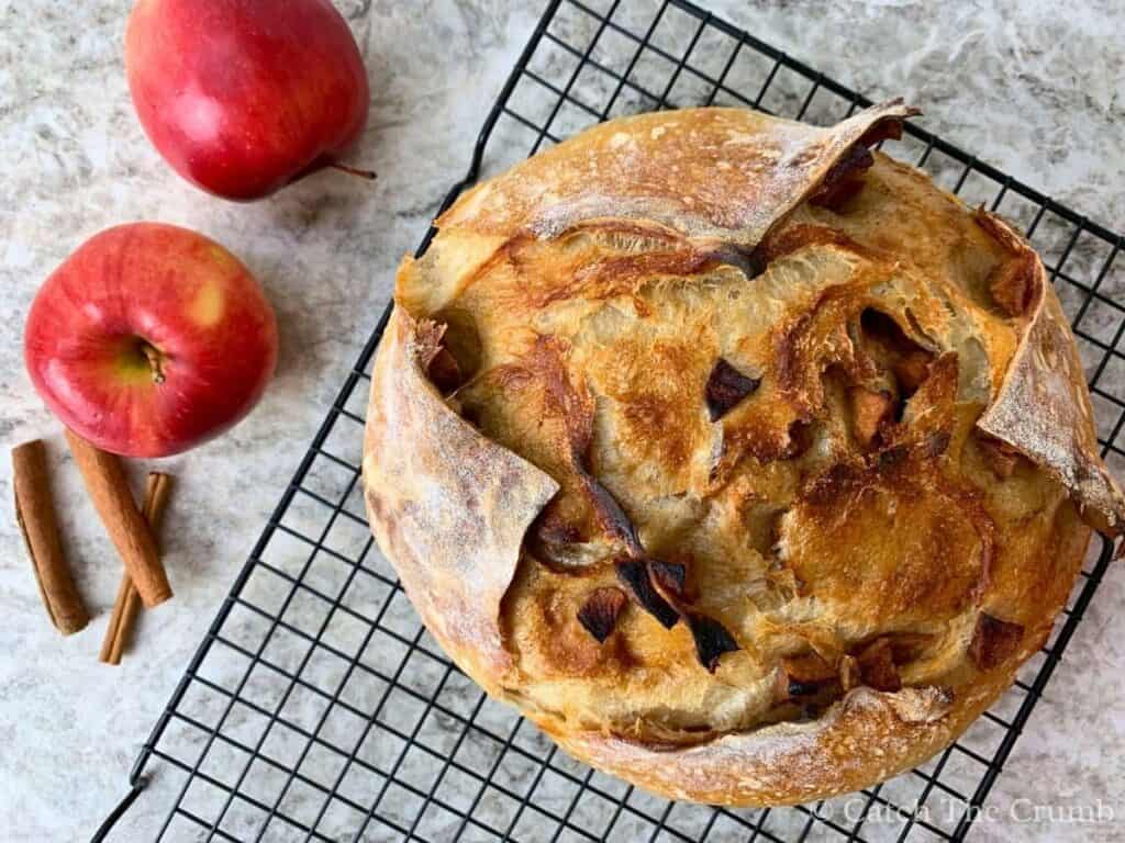 apple pie sourdough bread sitting on a cooling rack