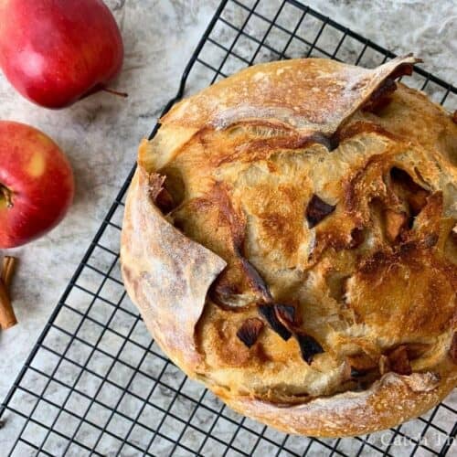 apple pie sourdough bread sitting on a cooling rack