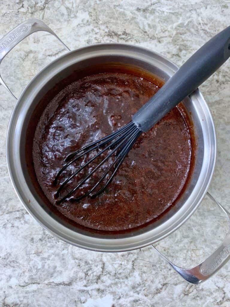 a saucepan containing cocoa powder, butter, sugar, and milk all melted together