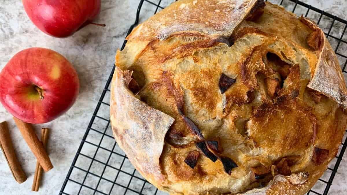 apple pie sourdough bread sitting on a cooling rack