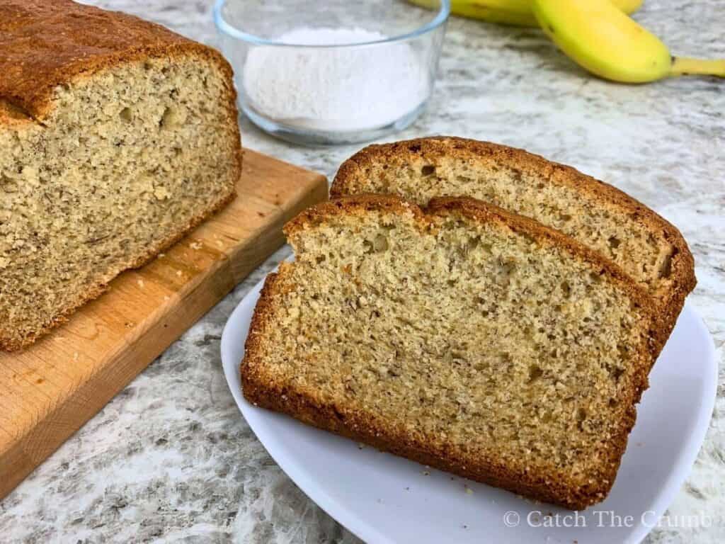 two slices of banana bread on a plate next to a loaf