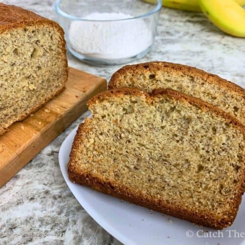 two slices of banana bread on a plate next to a loaf