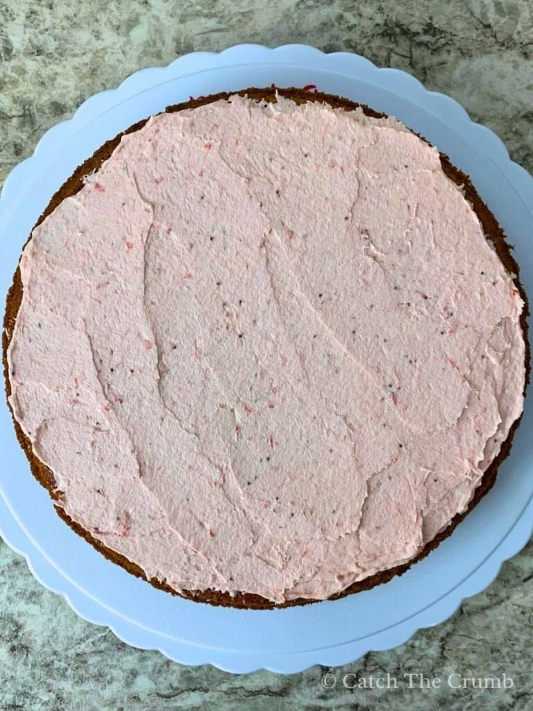a generous layer of strawberry buttercream spread over the first layer