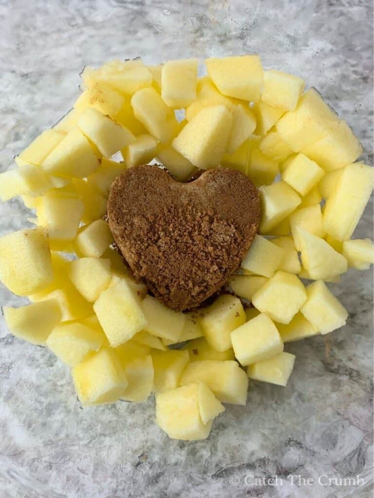 apple chunks surrounding a heart shape made from cinnamon and brown sugar