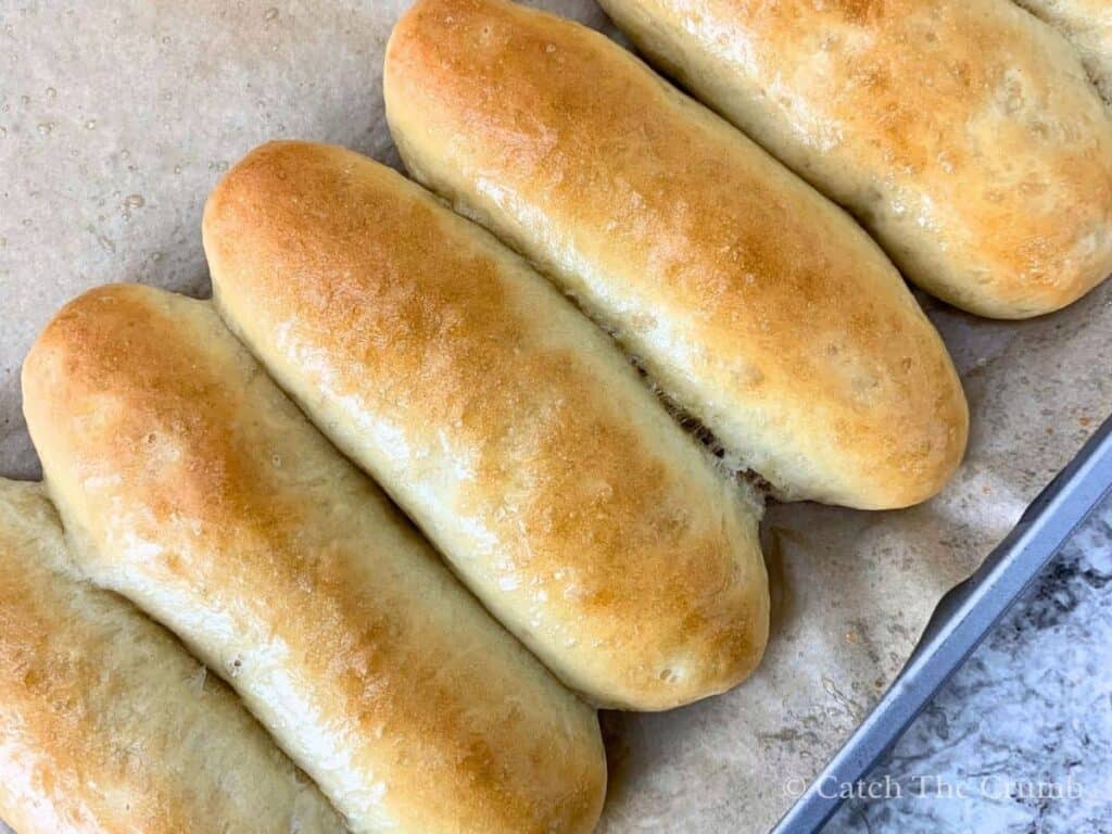 sourdough discard hot dog buns brushed with melted butter for soft, shiny tops