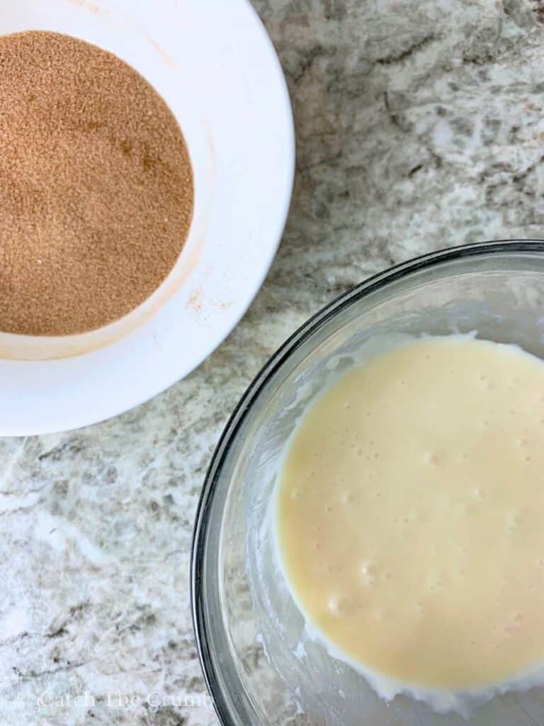 cinnamon and sugar mixed together in a bowl next to powdered sugar, melted butter, vanilla, and milk mixed together