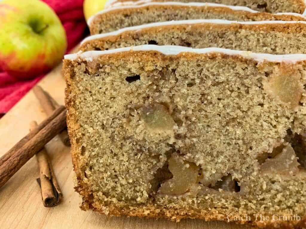 loaf of sourdough apple bread sliced on a cutting board