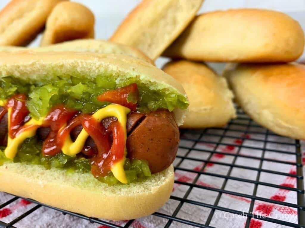 sourdough discard hot dog buns stacked around a bun with a sausage on it