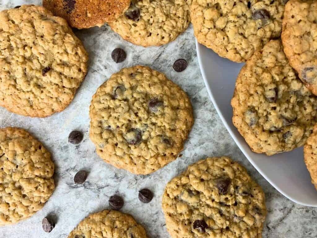 sourdough discard oatmeal chocolate chip cookies on a countertop with scattered chocolate chips
