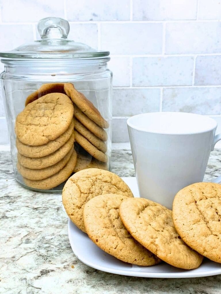 sourdough peanut butter cookies in a cookie jar and on a plate