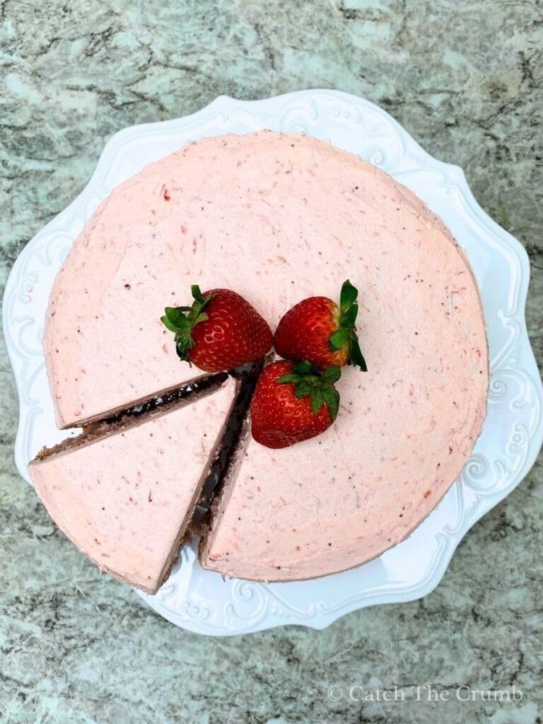 sourdough strawberry cake with a slice cut out on a cake plate