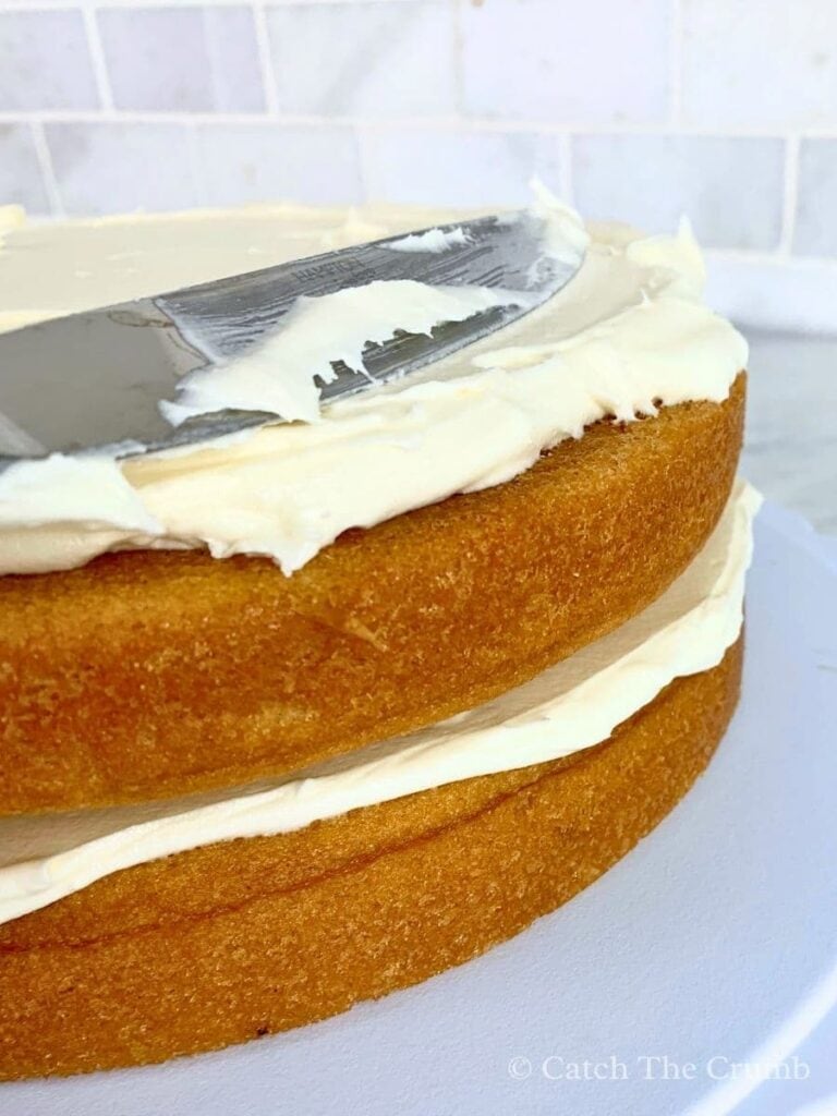 1 cup of buttercream spread evenly with a butter knife on the second layer of the sourdough vanilla cake
