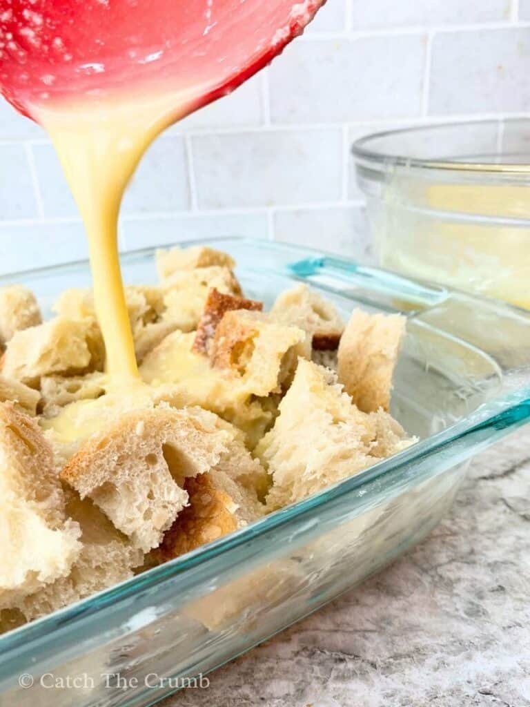 Pouring the mixture over the bread cubes