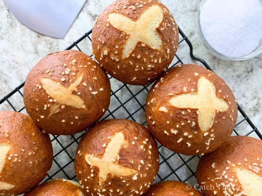sourdough pretzel buns sitting on a cooling rack